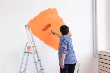 Evin içinde paten yapan orta yaşlı güzel bir kadın. Dekorasyon, yenileme, apartman onarımı ve ferahlatıcı konsept.