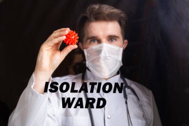 Covid-19 Koğuşu, Aşı Geliştirme ve Tıp Konsepti - Grip maskeli doktor Coronavirus 'un bir modelini tutuyor.