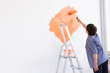 Evin içinde paten yapan orta yaşlı güzel bir kadın. Dekorasyon, yenileme, apartman onarımı ve ferahlatıcı konsept. Boşluğu kopyala.