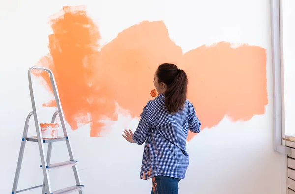 Ballando donna divertente pittura muro nel suo nuovo appartamento. Concetto di ristrutturazione e ridecorazione . — Foto Stock