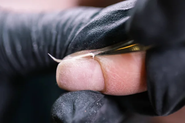 Женщина использует электрическую дрель для ногтей в салоне красоты. Маникюр ногтей процесс в деталях. Концепция полировки геля крупным планом. — стоковое фото