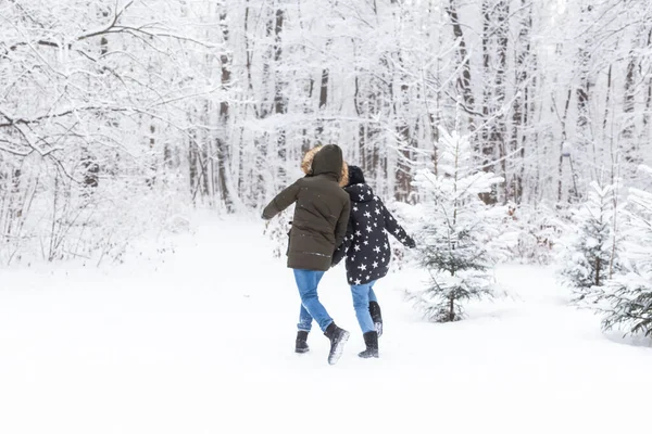 Joyeux couple marchant dans une forêt enneigée en hiver — Photo