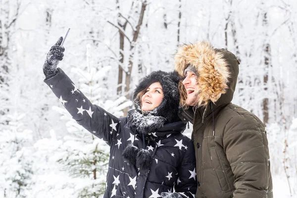 Concept de saison et de relation - Couple drôle prenant selfie en hiver — Photo