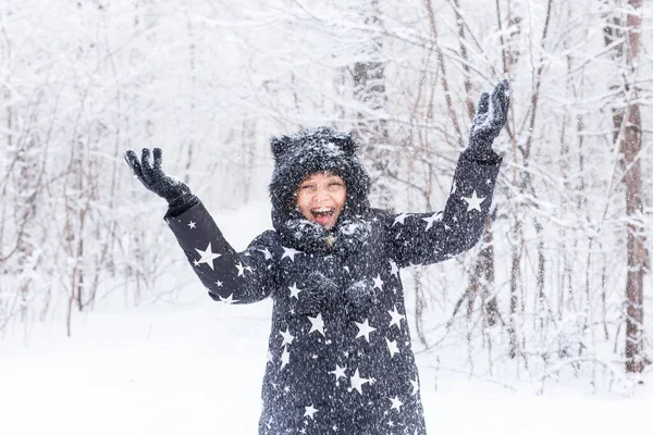 Joyeux jeune fille vomir une neige dans une forêt d'hiver — Photo