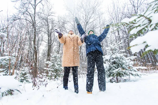 Концепція батьківства, веселощів і сезону Щаслива мати і син розважаються і граються зі снігом в зимовому лісі — стокове фото