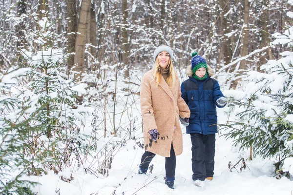 어버이, 재미, 계절 개념 - 행복 한 어머니 와아들이 겨울 숲에서 재미를 보며 눈 놀이를 하는 모습 — 스톡 사진