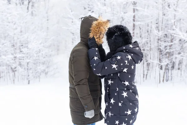 Jovem casal apaixonado se divertir na floresta nevada. Férias activas de Inverno. — Fotografia de Stock