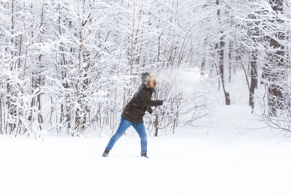 Estilo de vida, temporada e conceito de lazer - Engraçado casal jogando bola de neve no parque de inverno — Fotografia de Stock