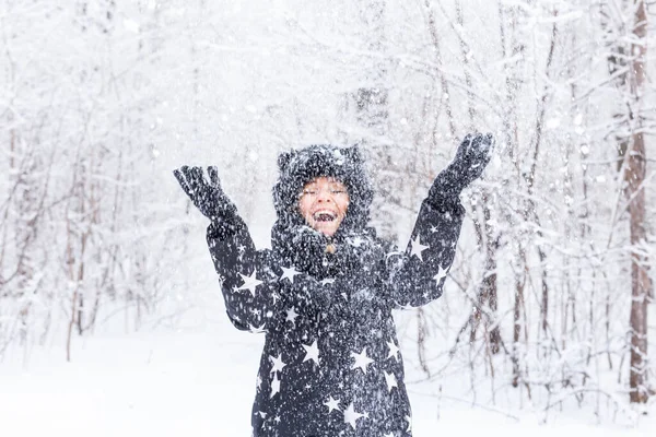 幸せな若い女の子は冬の森の中で雪を投げる — ストック写真