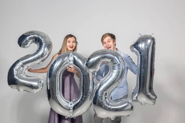 Fiesta, personas y año nuevo concepto de vacaciones - mujer y hombre celebrando la víspera de año nuevo 2021 — Foto de Stock