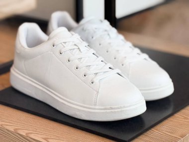 Mağazada sergilenen bir çift beyaz spor ayakkabı. Ayakkabı modası, günlük yaşam tarzı ve günlük giysi için modern şehir tarzı..