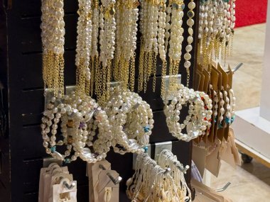 Perakende mağazasında zincir ve bileziklerle sergilenen inci ve altın mücevherler. Modern yaşam tarzında moda, süs ve lüks aksesuar, güzellik ve tüketici seçimi