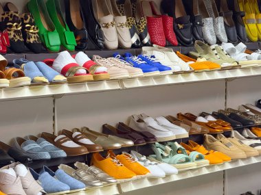 Bir mağazada gösterilen ayakkabı rafları, renkler ve tasarımlar. Moda, tüketici seçimi ve perakende ticaret bireyselliğin, yaşam tarzının ve modern eğilimlerin bir simgesi olarak