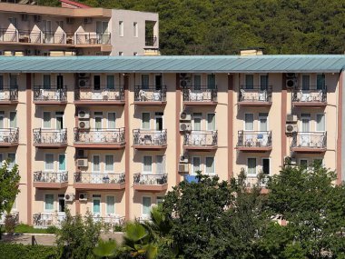 Balkonları ve klimaları olan çok katlı bir otel binası. Mimarlık, kentsel konut, konaklama, konaklama, konukseverlik ve dış yapısal tasarım