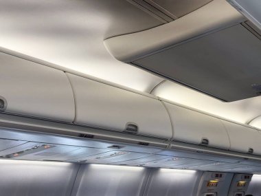 Bagaj bölmeleri ve kabin tavanı bir yolcu uçağının içinde. Seyahat, havacılık ve modern uçak kabinlerinde uzayın pratik tasarımı.