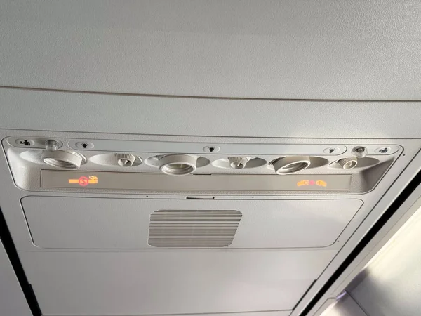 Hava delikleri ve ışık kontrollü uçak kabin paneline yakın çekim. Yolcu hizmeti ve havacılık mühendisliği