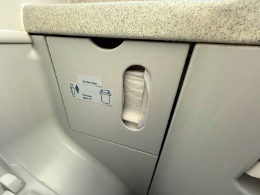Uçak tuvaleti atık öğütme kompartımanı. Üzerinde mendil ve tabela var. Hijyen, hijyen ve kompakt tasarım yolcu taşımacılığı için işlevsel destek sağlar