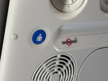 Uçak kabininde sigara içilmeyen ve mürettebat çağırma düğmesi olmayan üst panelin yakın çekimi. Uçuş güvenliği, havayolu yönetmeliği ve yolcu hizmet sistemi