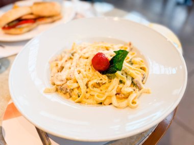 Parmesanlı, mantarlı ve domatesli makarna. Restoran yemek kültüründe mutfak, beslenme ve yaşam tarzı anları