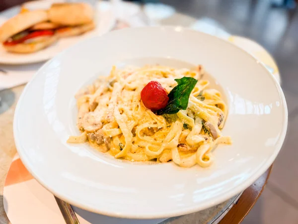 Parmesanlı, mantarlı ve domatesli makarna. Restoran yemek kültüründe mutfak, beslenme ve yaşam tarzı anları