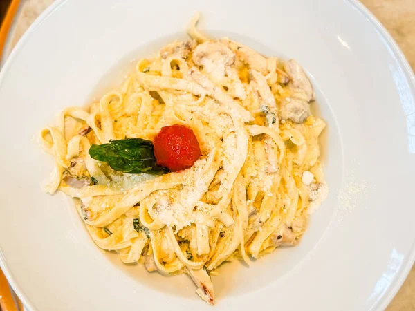 Parmesanlı, mantarlı ve domatesli makarna. Restoran yemek kültüründe mutfak, beslenme ve yaşam tarzı anları