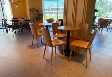 Tahta sandalyeler ve bir kafede yuvarlak masa. Minimalizm, modern yaşam tarzı ve kentsel yemek atmosferi