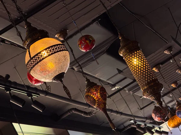 Asılma düzeninde kırmızı ve çok renkli camlı mozaik fenerler. Geleneksel zanaat, kültür sanatı ve miras aydınlatması konukseverliği ve canlı dekorasyonu simgeliyor.