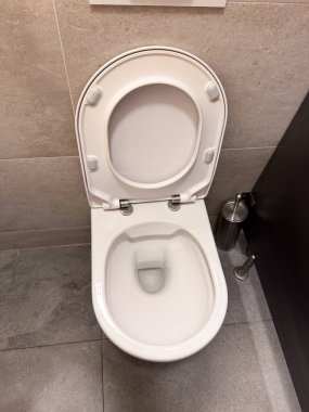 Modern tuvalet fayanslı banyo içi açık kapaklı. Temizlik, hijyen ve temizlik hizmetleri, tesis ve temel günlük kullanım koşullarını temsil etmektedir.