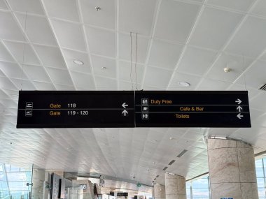 Havaalanı yön tabelası ve terminal koridorunda geçit bilgileri var. Seyahat navigasyonu, yolcu yönlendirmesi ve havacılık altyapısı için kamu tesisi tabelası