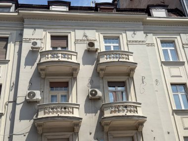 Şehir ortamında balkonlarla ve dekoratif mimari süslemelerle dolu tarihi bir cephe. Konut ve kültürel gelenek, yaşam tarzını, mirasını ve mahalle tasarımını yansıtıyor.