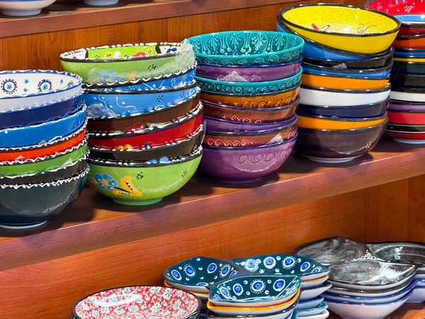 El yapımı seramik kaseler bir dükkanda raflarda sergileniyor. Renkli kültür sunumunda sanatsal çömlek, zanaat ve geleneksel tasarım