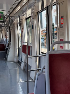 Tramvay içi koridor ve kapıların yanındaki koltuklar. Toplu taşıma, taşınabilirlik ve günlük seyahat altyapıyı, şehir yaşam tarzını ve yolcu yolculuğunu yansıtıyor