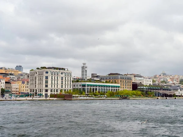 Tarihi otel ve modern binalarla şehir liman manzarası. İstanbul 'da turizm, kentsel yaşam tarzı ve mimari çeşitlilik