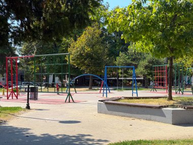 Salıncakları ve tırmanma çerçeveleri olan boş bir oyun alanı. Kentsel altyapı ve çocukluk eğlencesi