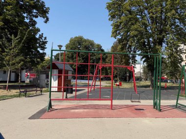 Salıncakları ve tırmanma çerçeveleri olan boş bir oyun alanı. Kentsel altyapı ve çocukluk eğlencesi