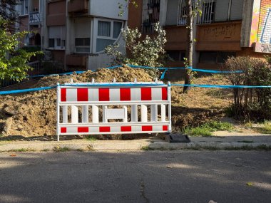 Toprak yığınının önüne kırmızı ve beyaz çizgili bariyer yerleştirildi. İnşaat alanı, altyapı onarımı ve güvenlik önlemi ve yönetmelik uygulaması ile kentsel bakım