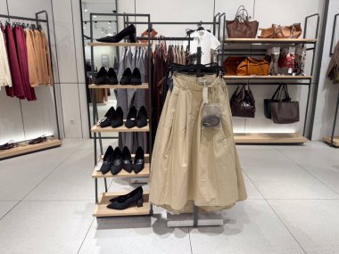 Ayakkabılar, etekler ve deri çantalar bir moda mağazasının bir bölümünde birlikte sergilenir. Perakende ticaret, tüketici seçimi, aksesuarlar, tekstil ve modern alışveriş kültüründe giyim ticareti.