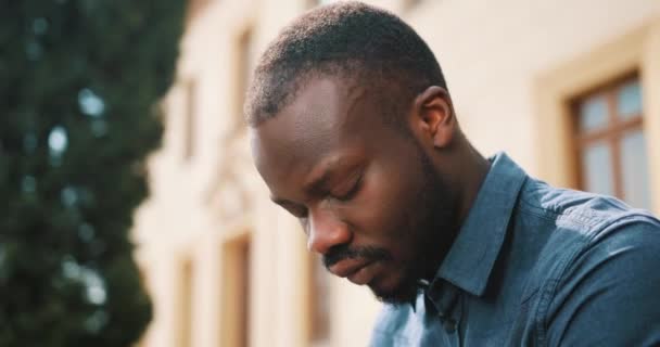 L'homme afro-américain fatigué est assis sur le banc dehors. Un homme triste, frustré, dit non — Video