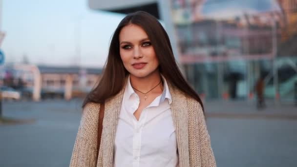 Encantadora jovem caminha ao longo da rua após o trabalho nas luzes do sol da noite — Vídeo de Stock