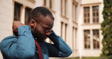 Yakışıklı Afrikalı-Amerikalı işadamı onun kravat ayakta sokakta giderir.