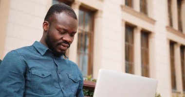 Afro-Amerikan bussinesman bankta oturur ve onun dizüstü bilgisayarda çalışır. Diz üstü Park üzerinde işadamı