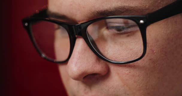 Primer plano de los ojos de los hombres en gafas mientras trabaja en la computadora portátil en la oficina — Vídeo de stock