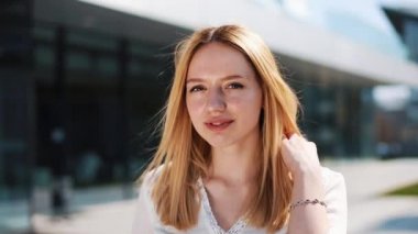 O dışında standları iken sarı saçlı kadının rüzgar esiyor