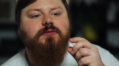 Şişman adam mısır yiyor ve Tv izliyor