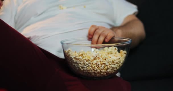 Gros homme prend pop-corn du bol avec sa main — Video