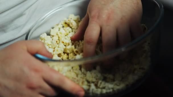 Dicke Männer nehmen Popcorn aus der Glasschüssel, schauen Fernsehsendungen und essen — Stockvideo