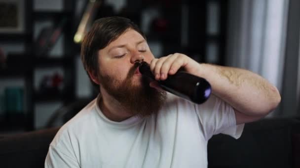 Le gros regarde la télé en train de boire de la bière — Video