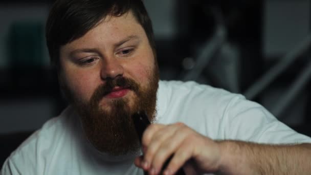 Tlustý muž pije pivo a čumí na televizi — Stock video