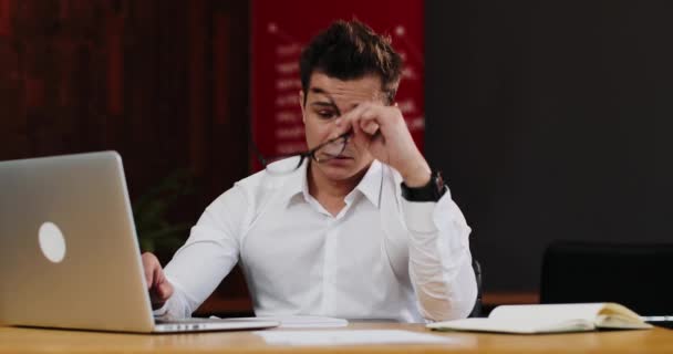 Hombre cansado se quita las gafas después de trabajar en el portátil — Vídeos de Stock