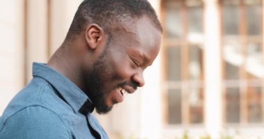 Dizüstü bilgisayarda çalışarak çekici Afrikalı-Amerikalı adam bankta oturur. Heyecanlı ve mutlu iyi haber aldı. Uzaktan serbest çalışıyorum. Başarı kavramı